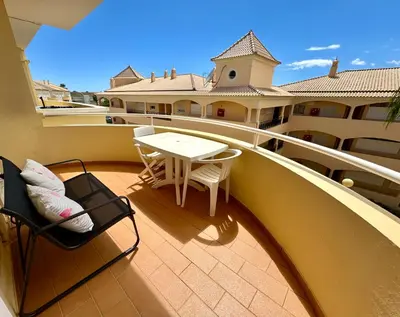 a balcony with a table and chairs on a building at Vilamoura-Praia da Falésia T2 in Quarteira