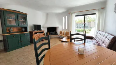 a living room with a wooden table and a couch at Sao Rafael T2 Duplex, Albufeira in Albufeira