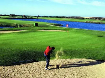 a man is standing on a golf course at Luxury Apart wStunning Sea Views, Walk Beach in Albufeira