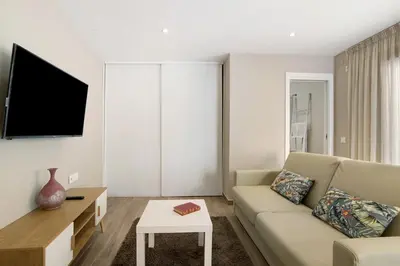 a kitchen and dining room with a table and a television at A Casa da Elsa in Faro