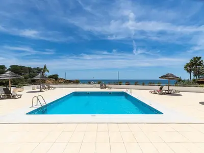 a swimming pool with the ocean in the background at Akisol Olhos de Água Lyrical in Albufeira