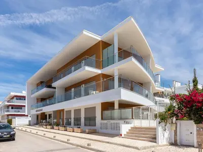 a white building with balconies on a street at Akisol Olhos de Água Lyrical in Albufeira
