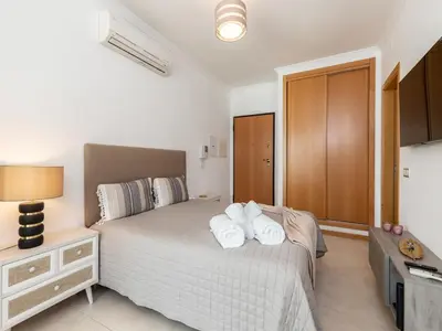 a bedroom with a bed with two towels on it at Akisol Olhos de Água Lyrical in Albufeira