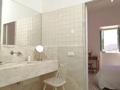a bathroom with a sink and a mirror and a bed at Eco-Villa Monte Do Barrocalinho in Loulé