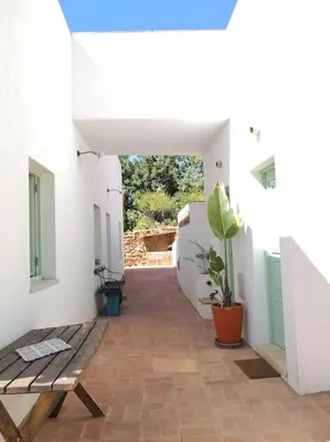 a hallway with a wooden bench in a white building at Eco-Villa Monte Do Barrocalinho in Loulé
