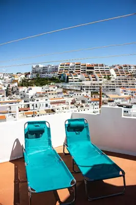 two blue chairs on a roof with a view of a city at Casa Clementina in Albufeira