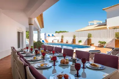 a patio with chairs and a swimming pool at Villa Cavi in Olhos de Água