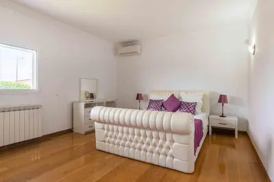 a bedroom with three beds and a window at Villa Cavi in Olhos de Água