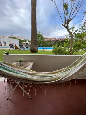 a hammock on a patio with a pool at LV Apartment Albufeira in Albufeira