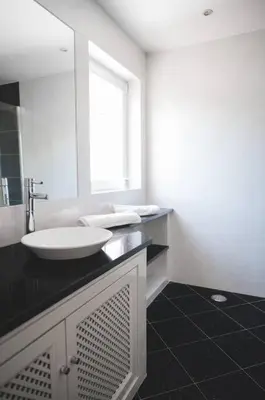 a white bathroom with a sink and a mirror at Casa das Palmeiras - Villa com piscina, BBQ e ar condicionado in Albufeira