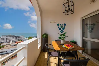 a balcony with a table and chairs and a view of the ocean at Sea View Central Town 2 Bedroom Apartment in Albufeira