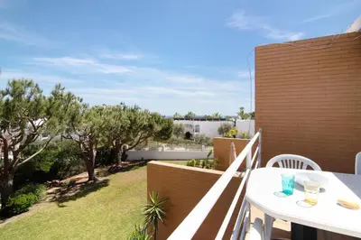 a balcony with a table and a view of a yard at Yara Beach Apartments T1 in Albufeira