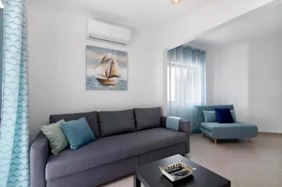 a living room with a couch and a chair at Apartamento Jade by Sunnyway in Albufeira