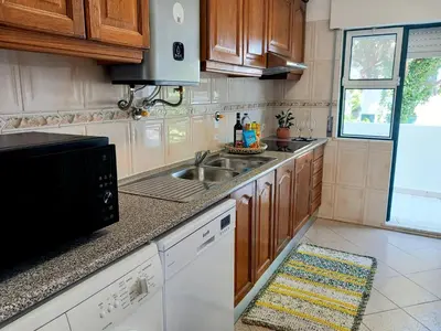 a kitchen with a sink and a microwave at Apartamento Jade by Sunnyway in Albufeira
