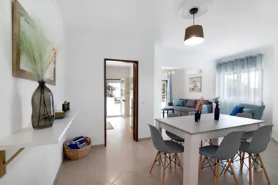 a dining room and living room with a table and chairs at Apartamento Jade by Sunnyway in Albufeira