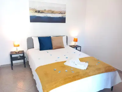 a bedroom with a large white bed with two lamps at Apartamento Jade by Sunnyway in Albufeira
