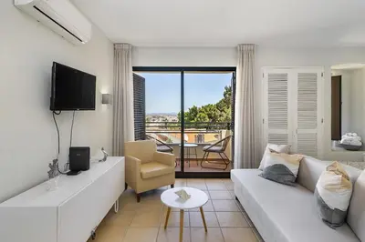 a living room with a white couch and a television at Garden Paradise, Old Town & Beach in Albufeira