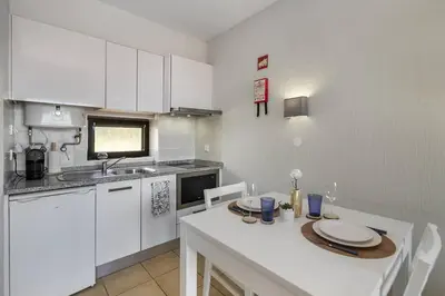 a kitchen with white cabinets and a table with plates on it at Garden Paradise, Old Town & Beach in Albufeira