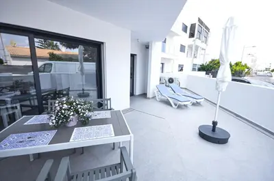 a patio with a table and chairs and an umbrella at Blue Horizons, (AT18) 2 Bedroom, Olhos de Agua in Olhos de Água