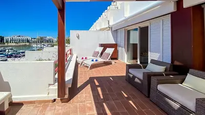 a patio with two chairs and a table on a balcony at Que sonho! Vista Marina T2 HsR Vilamarina in Vilamoura