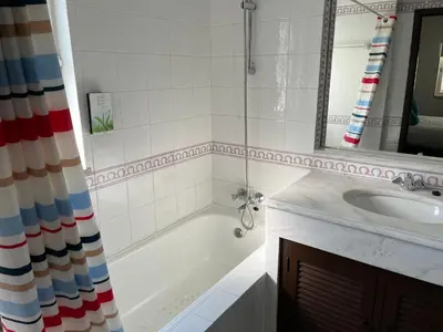 a bathroom with a tub and a sink and a mirror at House´s Golf in Almancil
