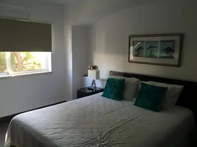 a bedroom with a bed with two green pillows at House´s Golf in Almancil