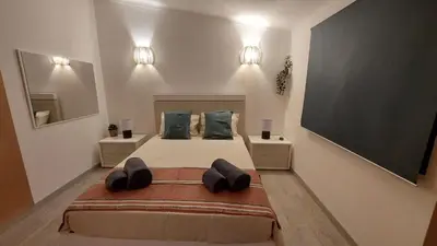 a bedroom with a large bed and a flat screen tv at Casa Azinheira - Albufeira in Albufeira