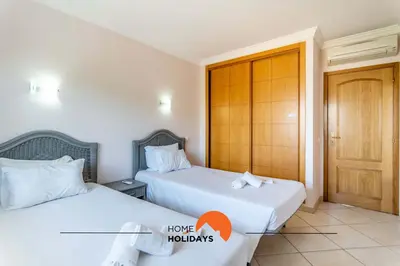 two beds in a hotel room with a door at #166 Frat Apartment by Home Holidays in Albufeira