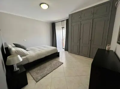 a bedroom with a bed and a table with a lamp at Luxury Modern Beach Apartment in Quarteira
