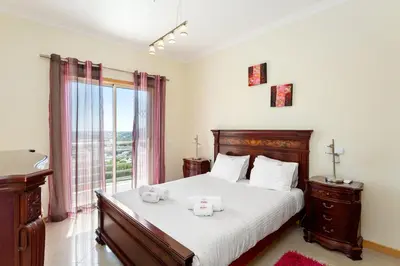 a bedroom with a bed with two stuffed animals on it at Encosta da Orada By Albufeira Rental in Albufeira