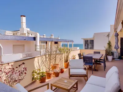 a patio with a table and chairs on a balcony at AL - Quarteira Terrace Penthouse in Quarteira