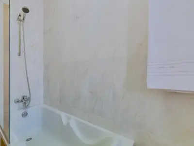 a bathroom with a white tub and a shower at AL - Quarteira Terrace Penthouse in Quarteira