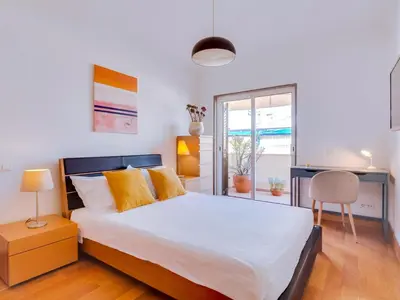 a bedroom with a bed and a desk and a window at AL - Quarteira Terrace Penthouse in Quarteira