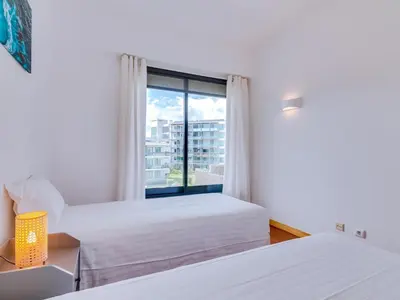 two beds in a room with a window at AL - Residence Golf Club Modern Apartment in Vilamoura