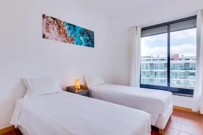 two beds in a room with a window at AL - Residence Golf Club Modern Apartment in Vilamoura
