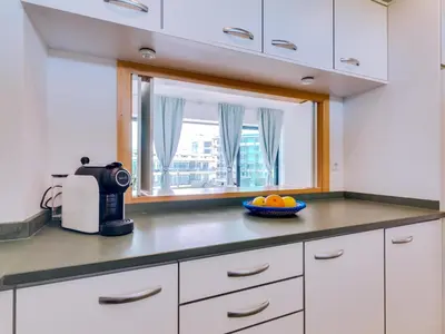 a kitchen with white cabinets and a bowl of fruit at AL - Residence Golf Club Modern Apartment in Vilamoura
