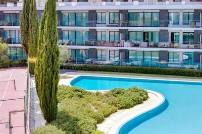 an image of a swimming pool in front of a building at AL - Residence Golf Club Modern Apartment in Vilamoura