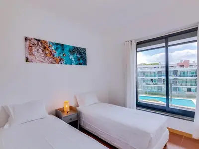 a bedroom with two beds and a large window at AL - Residence Golf Club Modern Apartment in Vilamoura