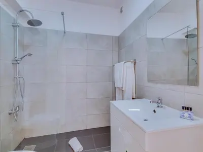 a white bathroom with a sink and a shower at AL - Apartamento Village Atlântico in Vilamoura