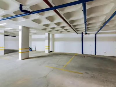 an empty parking garage with white walls and blue beams at AL - Apartamento Village Atlântico in Vilamoura