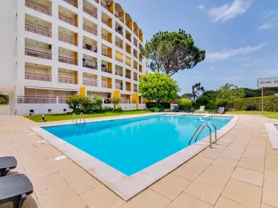 a swimming pool in front of a building at AL - Apartamento Village Atlântico in Vilamoura