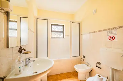 a bathroom with a white sink and a mirror at Villa Pinheiro in Albufeira