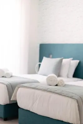 two beds with towels on top of them in a bedroom at Orange Boutique Residence - Casa Diogo in Quarteira