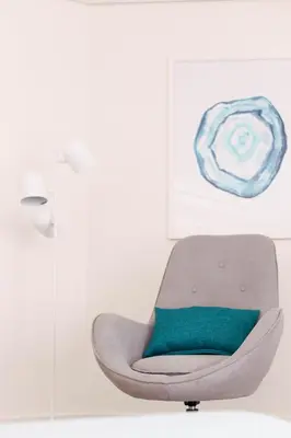 a grey chair with a green pillow in a room at Orange Boutique Residence - Casa Diogo in Quarteira