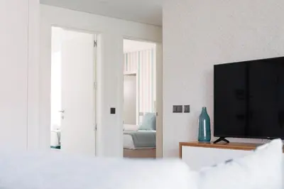 a living room with a television and a bedroom at Orange Boutique Residence - Casa Diogo in Quarteira