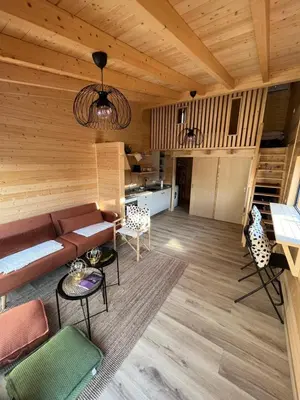 a living room with a couch and some chairs at Wood11 - Charming TinyHouse in a Lovely Garden in Santa Bárbara de Nexe