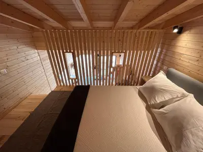 a bedroom with a bed in a wooden room at Wood11 - Charming TinyHouse in a Lovely Garden in Santa Bárbara de Nexe