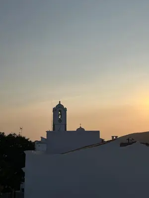 a clock tower on top of a building at sunset at Wood11 - Charming TinyHouse in a Lovely Garden in Santa Bárbara de Nexe