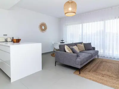 a living room with a couch and a kitchen at Green 1 Apartment by Stay ici Algarve Holiday Rental in Albufeira
