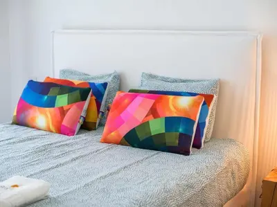 two colorful pillows sitting on a bed at Green 1 Apartment by Stay ici Algarve Holiday Rental in Albufeira